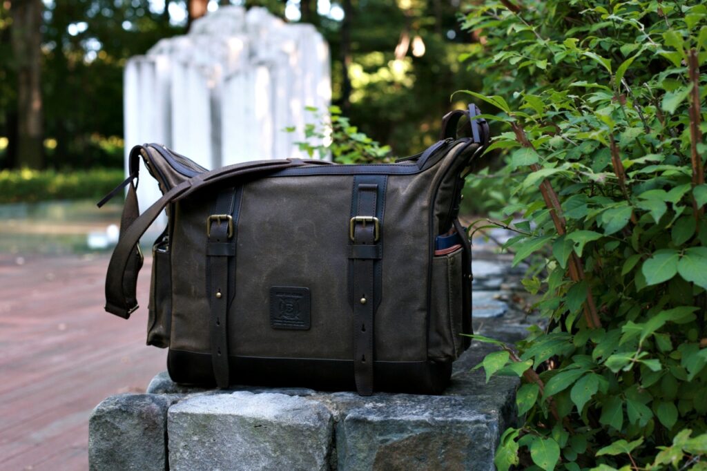 Builford Classic Hobo bag sitting on a stone wall, showing the front buckles and organized pocket structure.